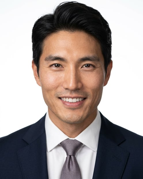 White / Pure White Studio · Navy tailored suit headshot example