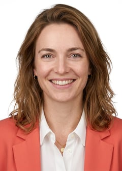 Professional AI LinkedIn headshot in Coral blazer over white blouse on White / Pure White Studio