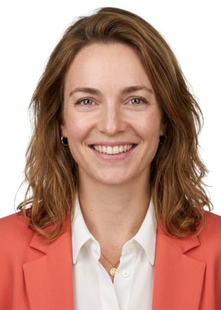 Professional AI LinkedIn headshot in Coral blazer over white blouse on White / Pure White Studio