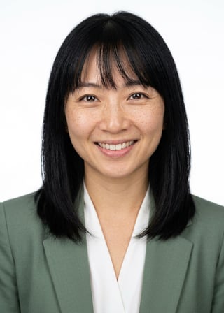Professional AI LinkedIn headshot in Sage green blazer with white blouse (2026 trend) on White / Pure White Studio