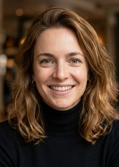 Professional AI LinkedIn headshot in Fitted black turtleneck on Cafe (warm professional)
