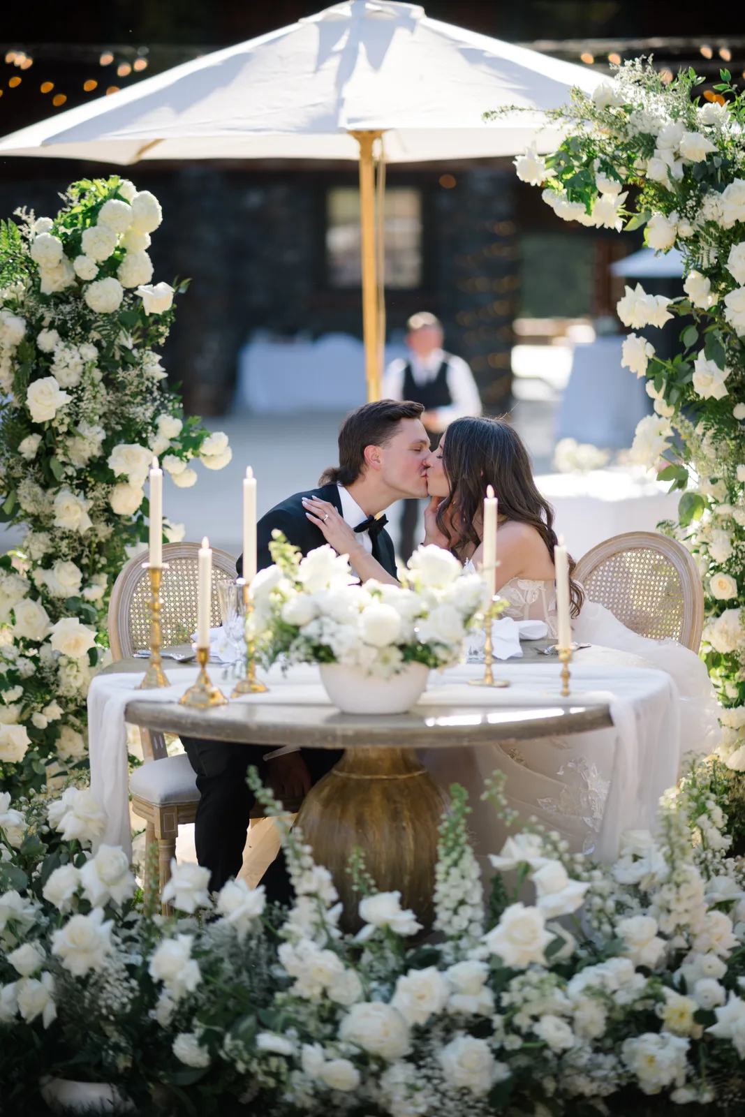 Flowers around couple sitting at lush wedding table