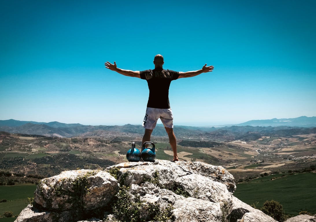 Taco Fleur with arms raised on El Torcal, Spain — barefoot on ancient rock under blue sky