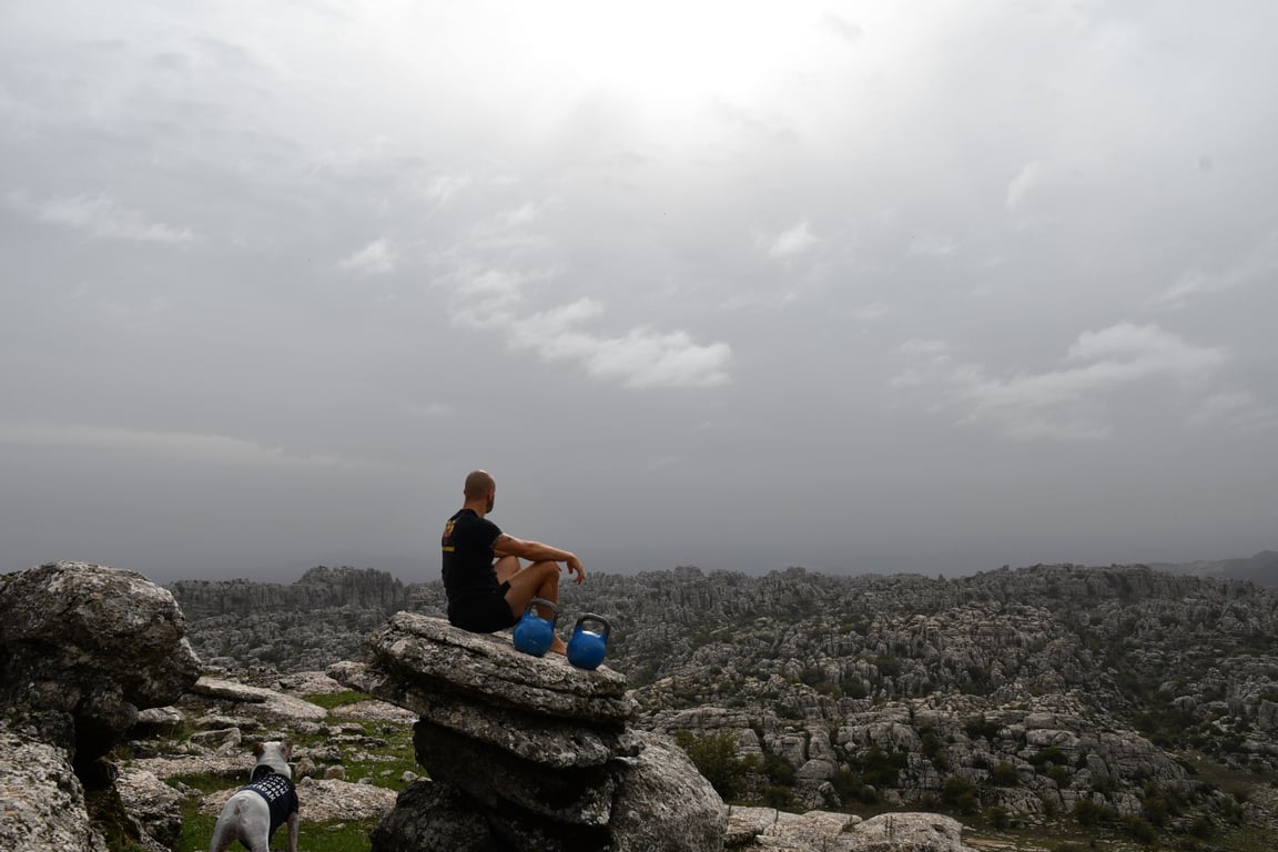 Taco Fleur sitting on limestone at El Torcal with kettlebells and Nacho the French Bulldog