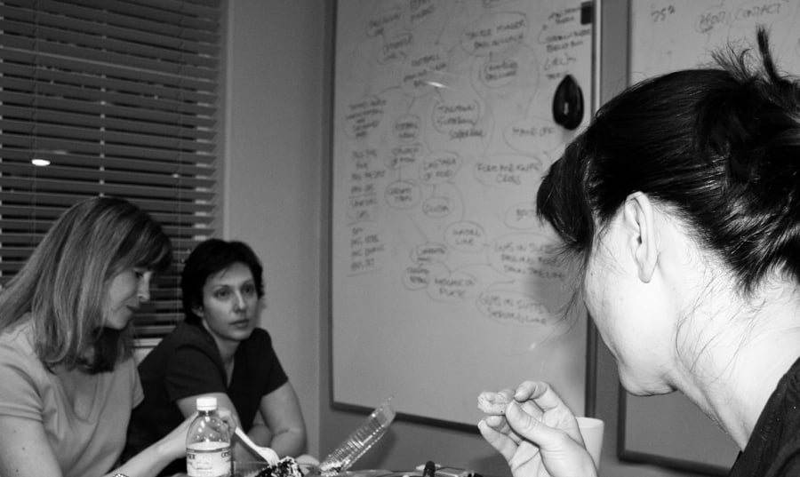A group of women brainstorming in front of a whiteboard
