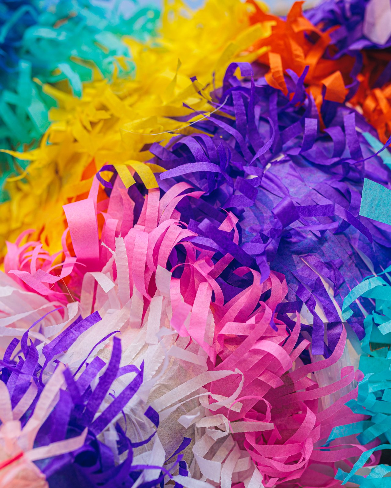 A close-up of the fringed tissue paper of a handmade piñata