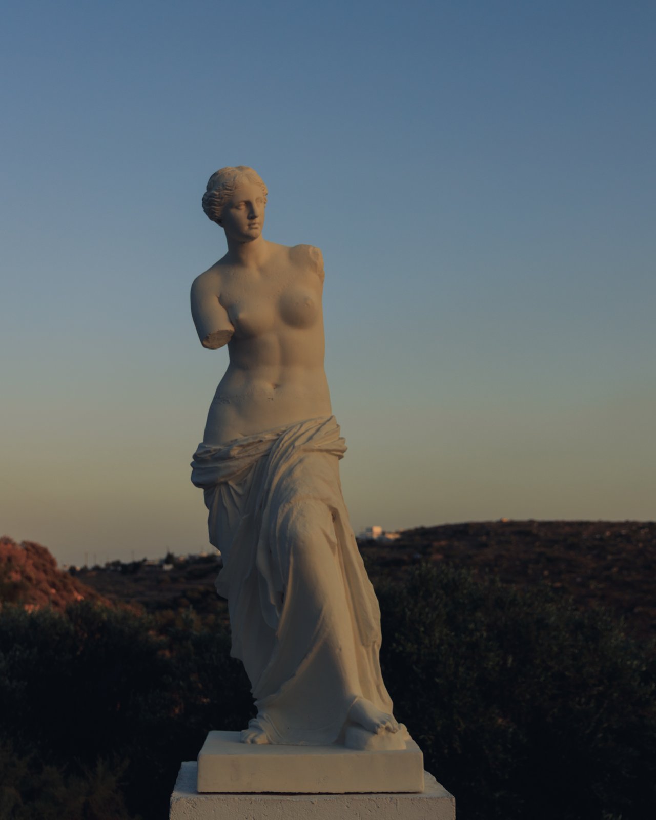 A Venus de Milo replica on a headland at dusk, Milos, Greece