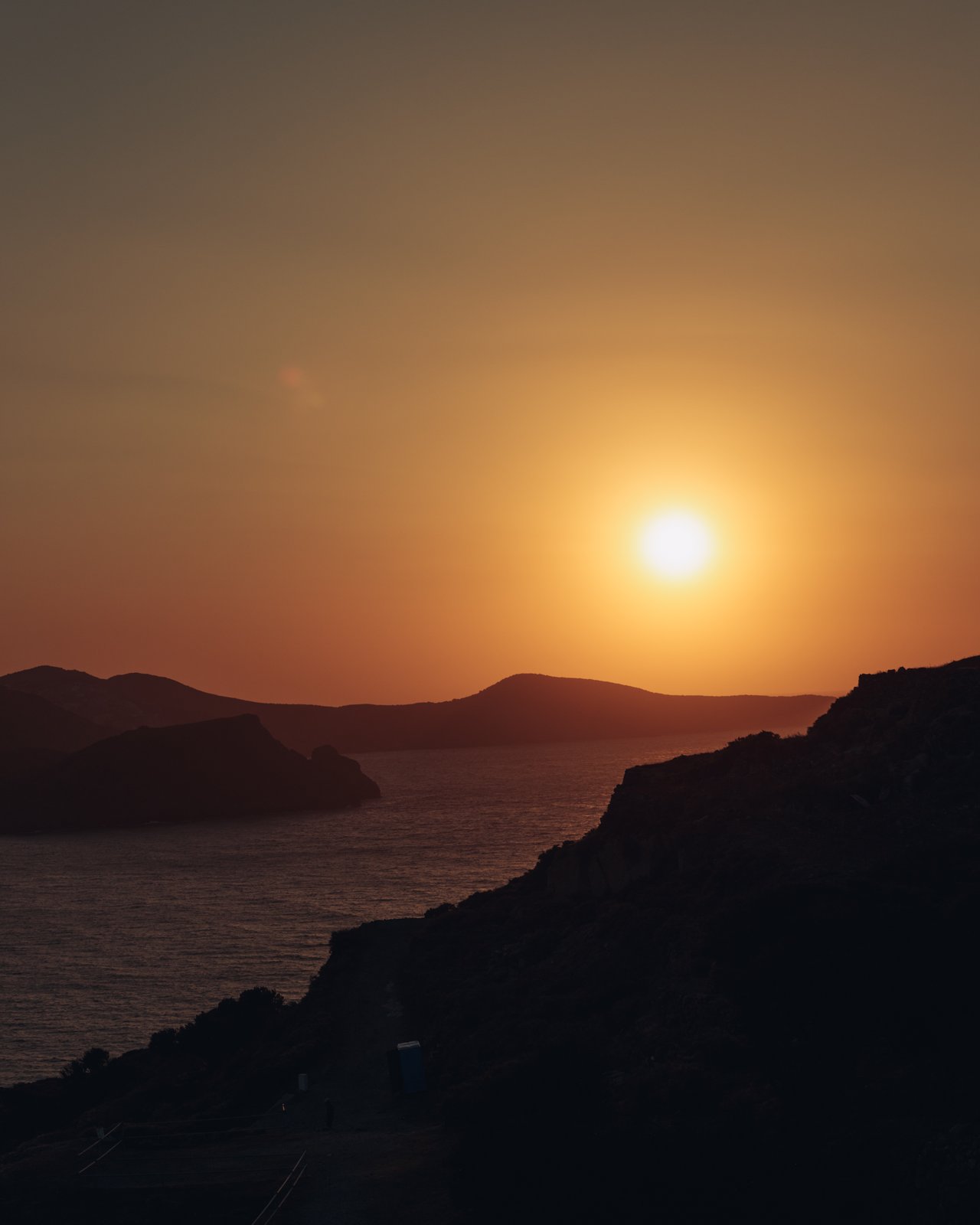The sun setting over the sea and island silhouettes, Greece