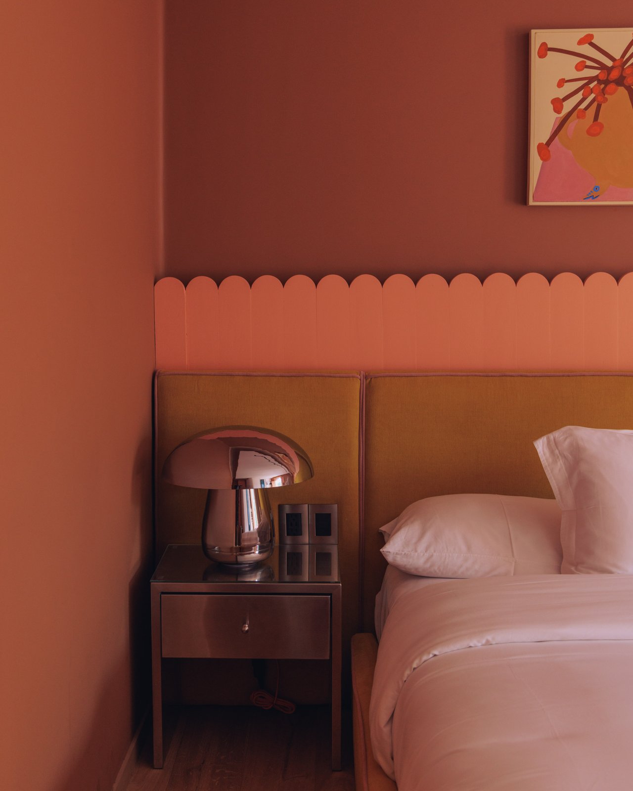 A guest room with a chrome mushroom lamp, a scalloped headboard and terracotta walls, Ignacia Guest House