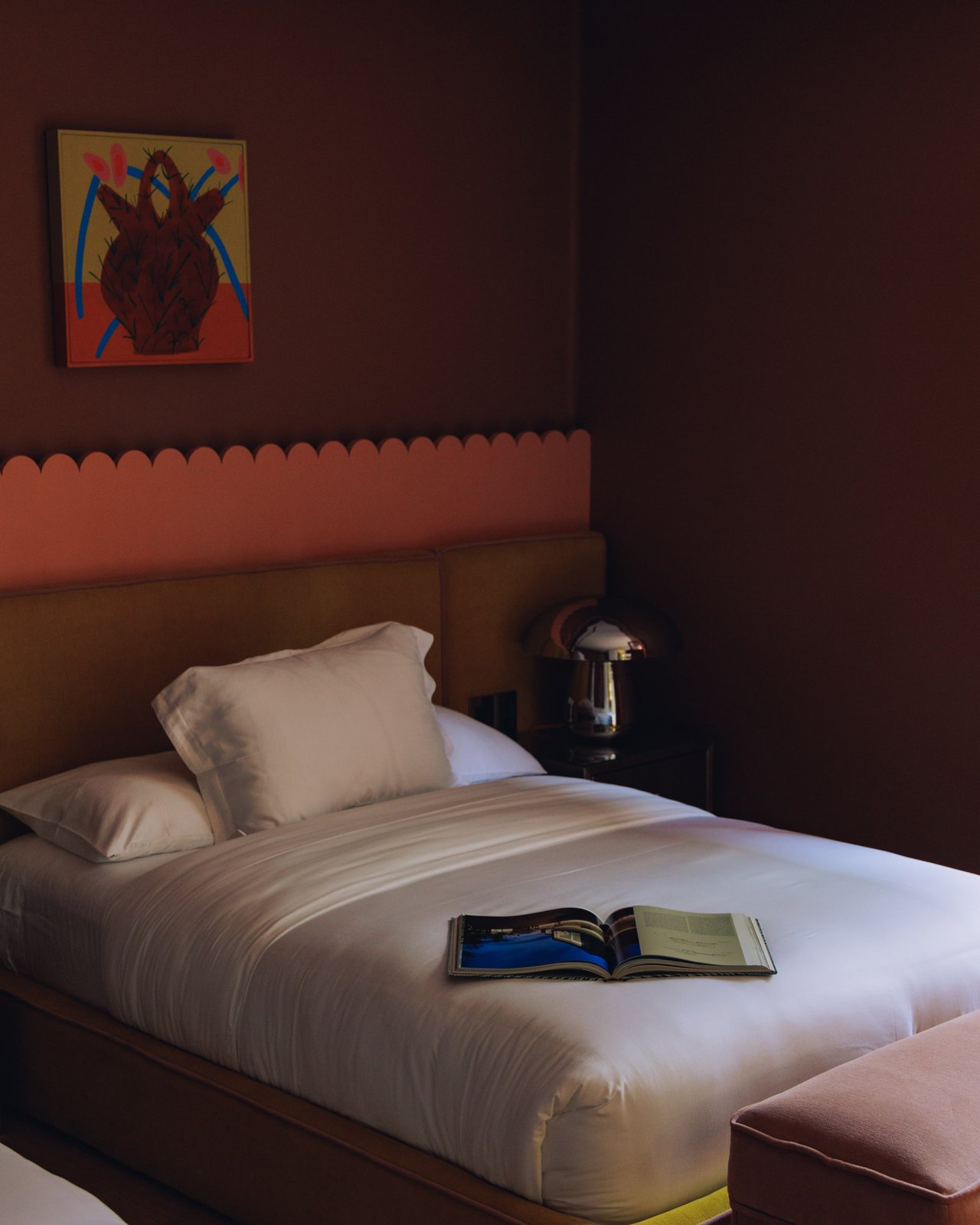 A single bed with a scalloped headboard, a mushroom lamp and an open book, Ignacia Guest House