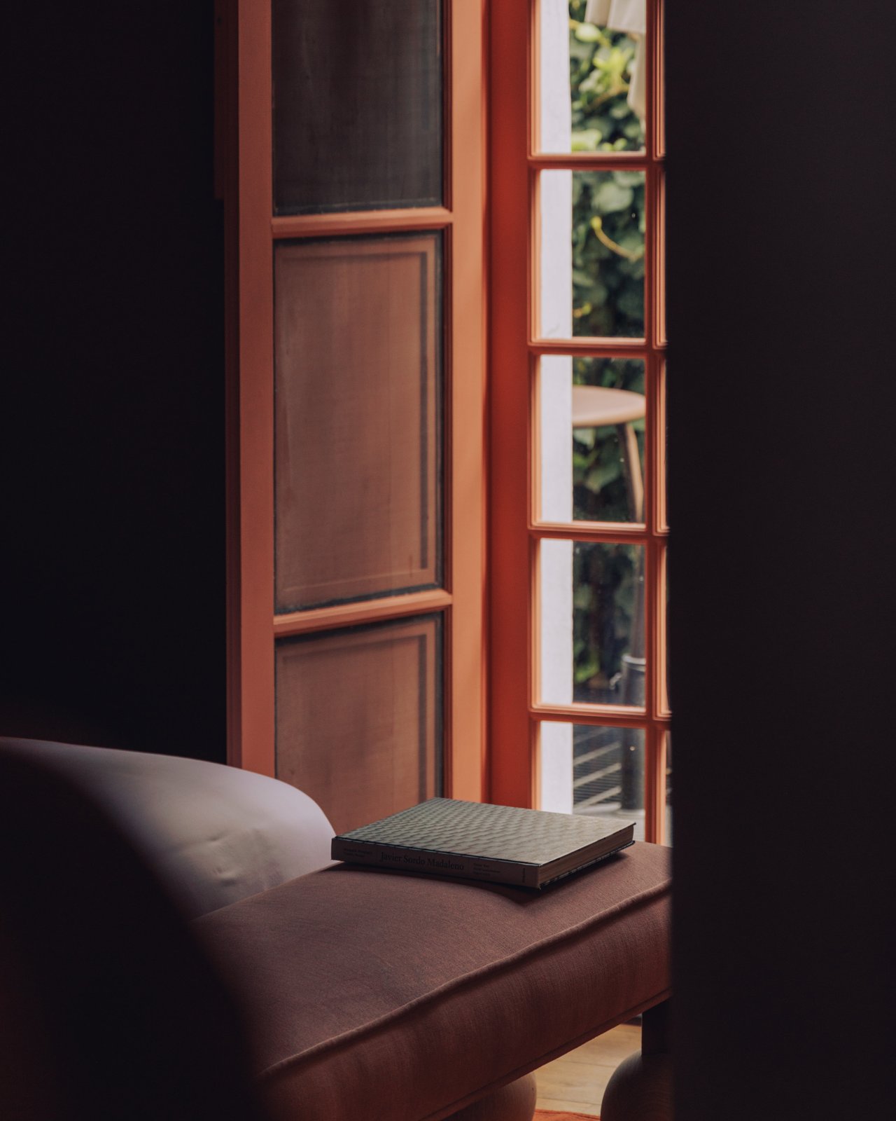 A leather daybed by a tall reeded-glass window, Ignacia Guest House