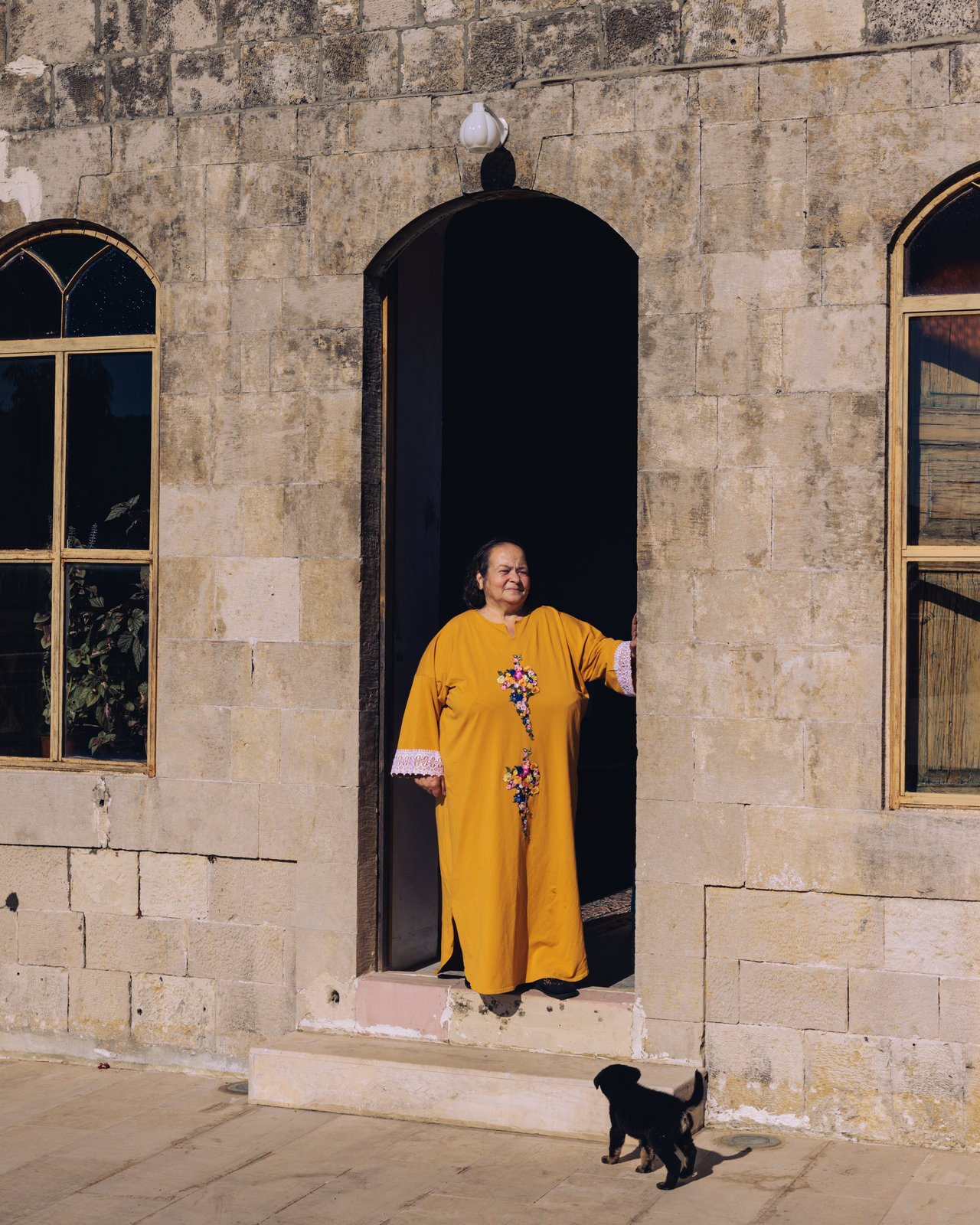 A minaret and harbour framed through a narrow slit window in old stone, Lebanon
