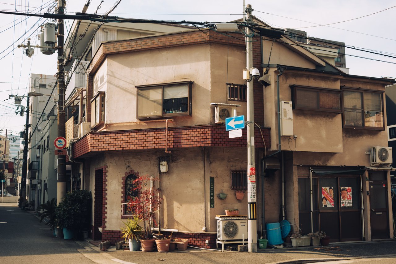 A quiet old residential corner with a two-storey house and a one-way sign, Osaka