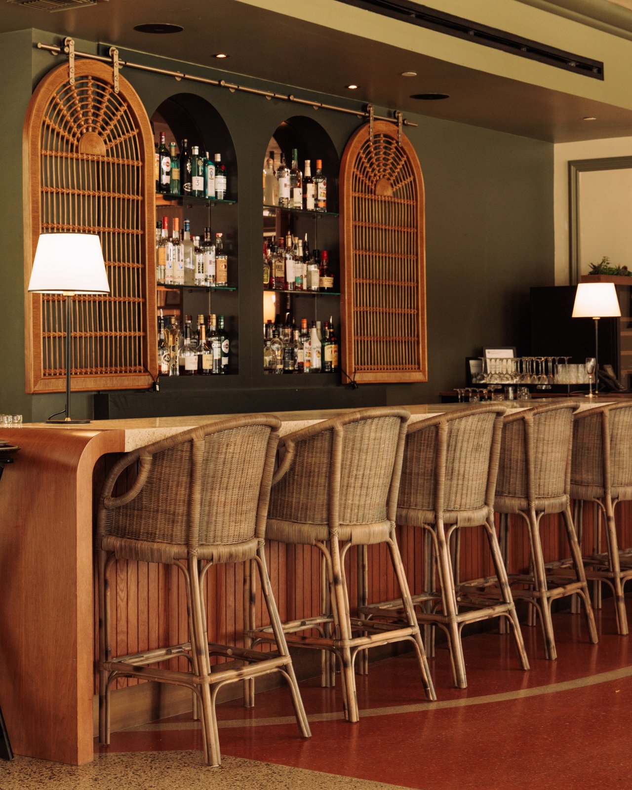The hotel bar with rattan stools and arched cane liquor cabinets, The Balfour Hotel, Miami Beach