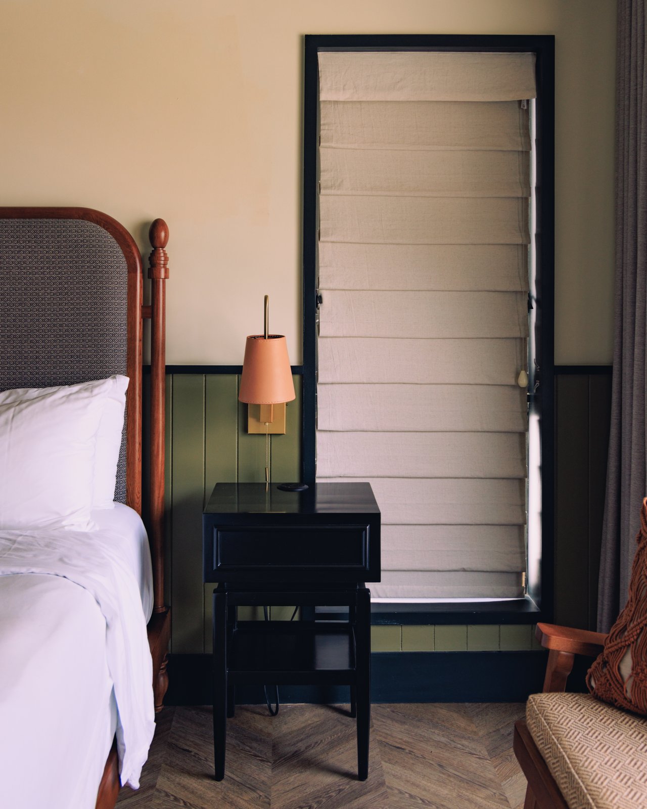 A guest room with a four-poster bed and a shuttered door over a herringbone floor, The Balfour Hotel