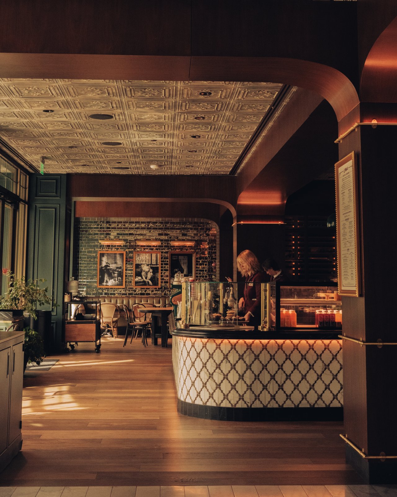 The lobby lounge — a curved bar, patterned tile floor and a pressed-tin ceiling