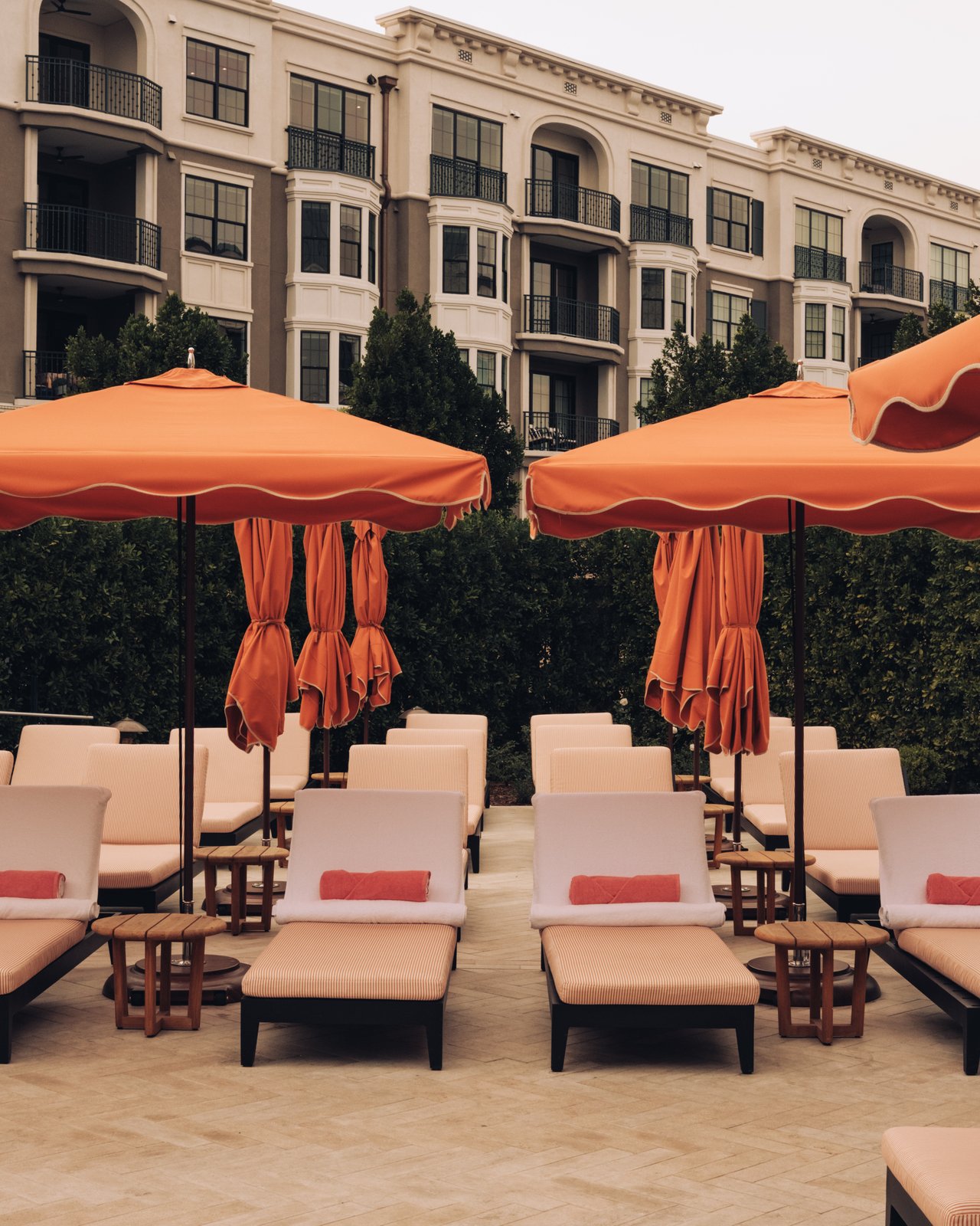 The pool deck with scalloped orange umbrellas and white chaise lounges