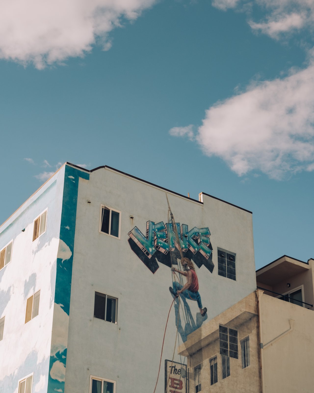 A muralled Venice building with a painted climber scaling its wall