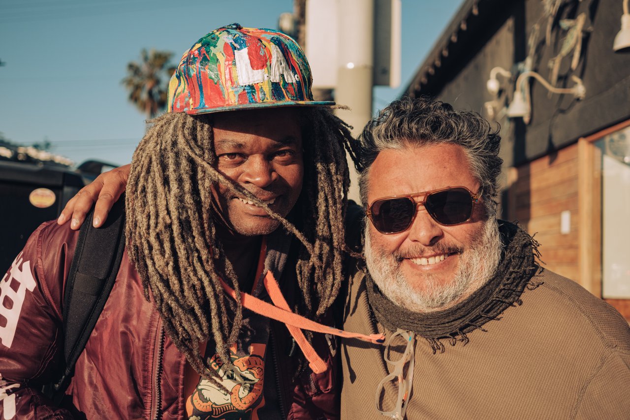 Two friends posing together on the boardwalk, one with dreadlocks, Venice