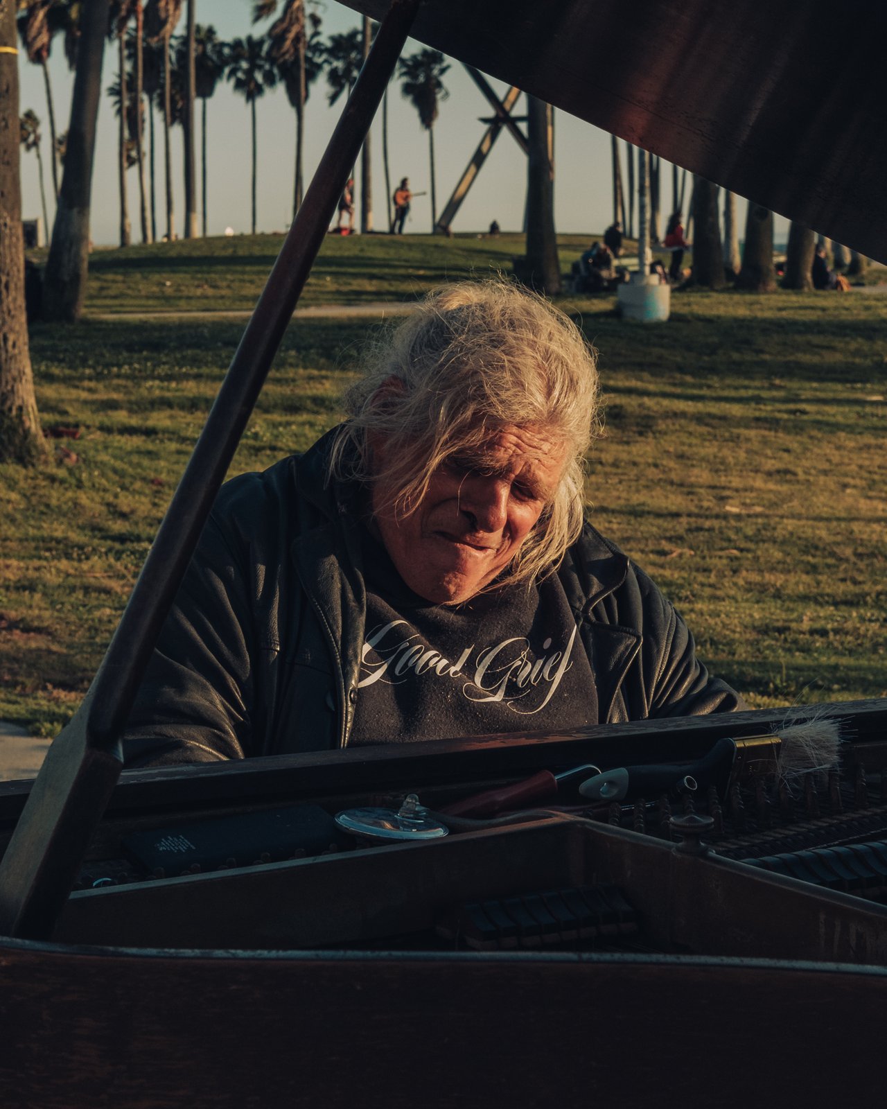 A portrait of a long-haired man in a 'Good Grief' hoodie, Venice