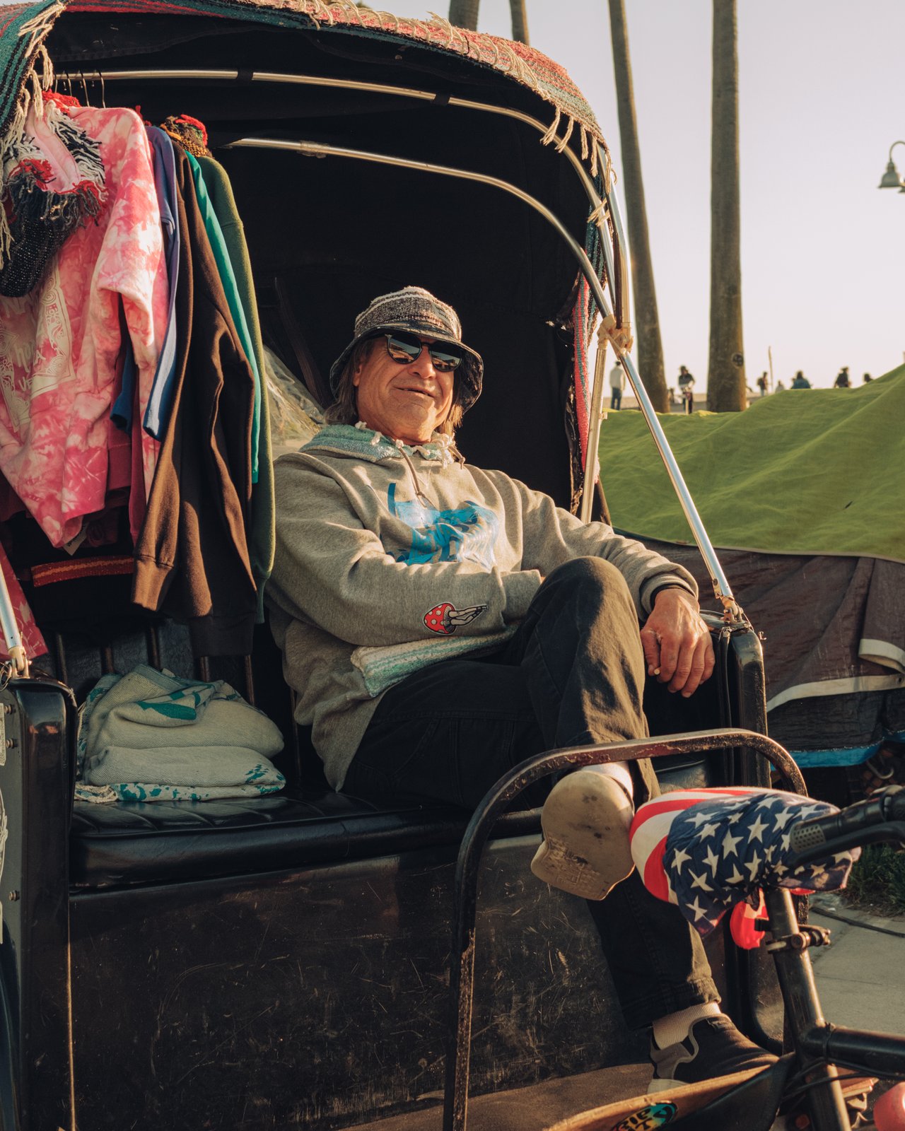 A man seated in a canopied bike-cart piled with belongings, Venice