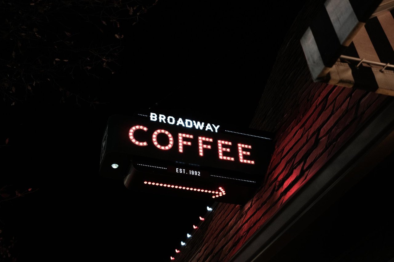 A 'Broadway Coffee' neon sign glowing at night, Kansas City