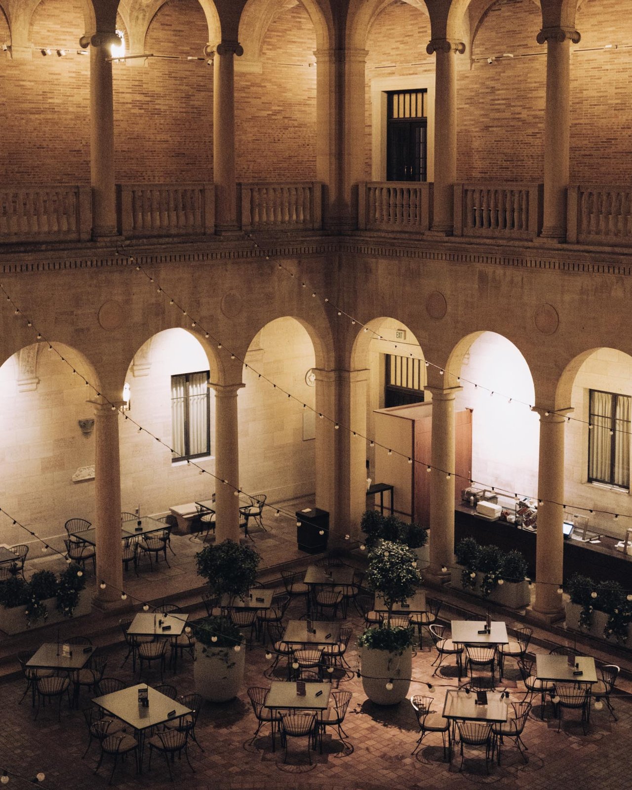 A string-lit arcaded courtyard set with cafe tables, Kansas City