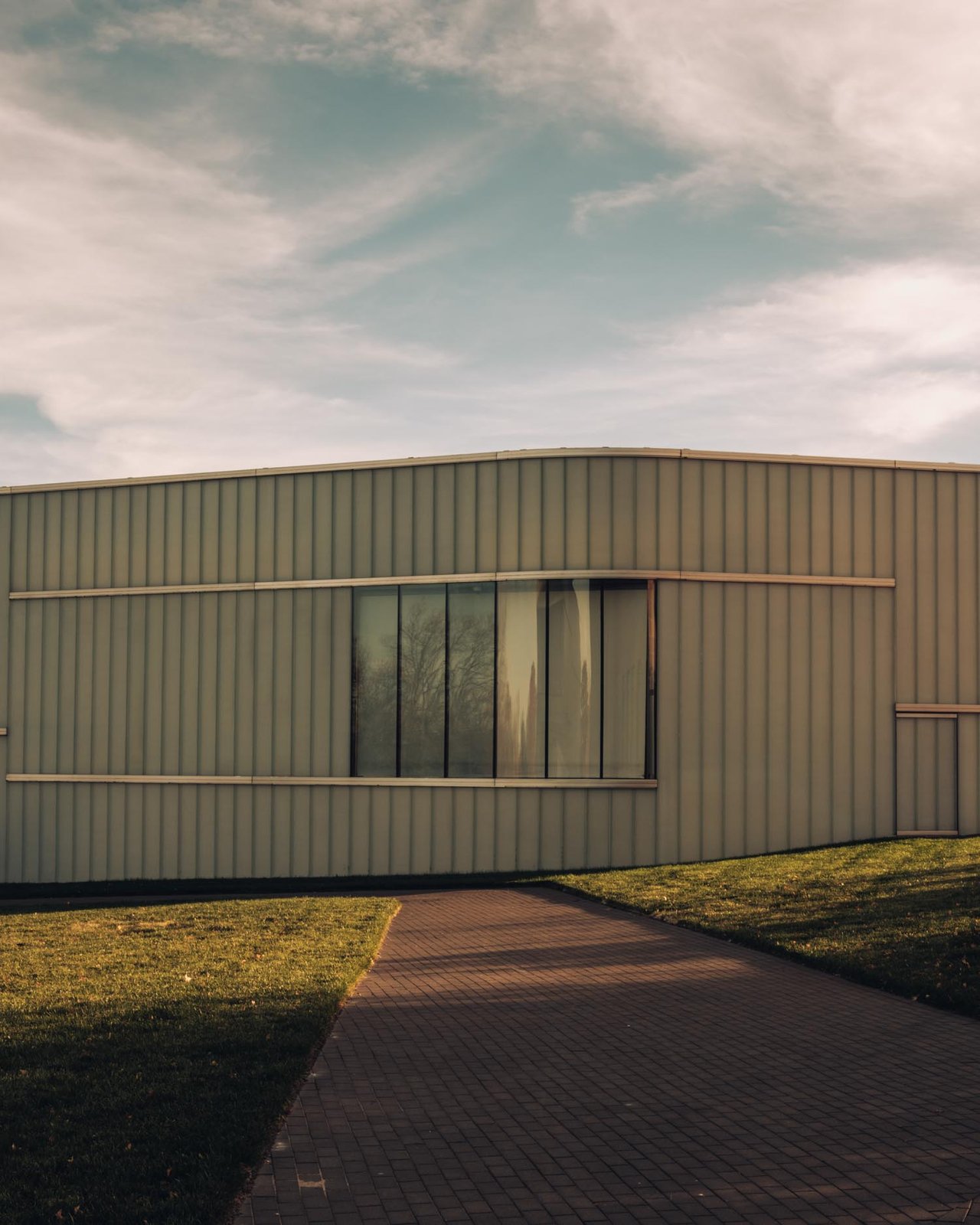 The low translucent Bloch Building of the Nelson-Atkins over a brick path and lawn, Kansas City
