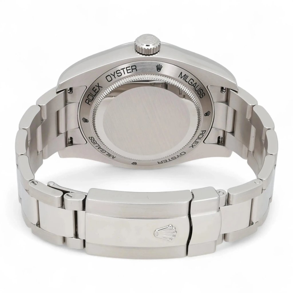 An image of a pre-owned men's Rolex wristwatch, viewed from the back at a slight angle, showcasing its metallic bracelet and clasp. The focus is on the watch's case back, engraved with "Rolex Oyster Milgauss," and the Rolex logo on the clasp. The angle highlights the watch's polished and brushed finishes, emphasizing its sturdy design. The image captures the watch from a close distance, providing a clear view of its craftsmanship.