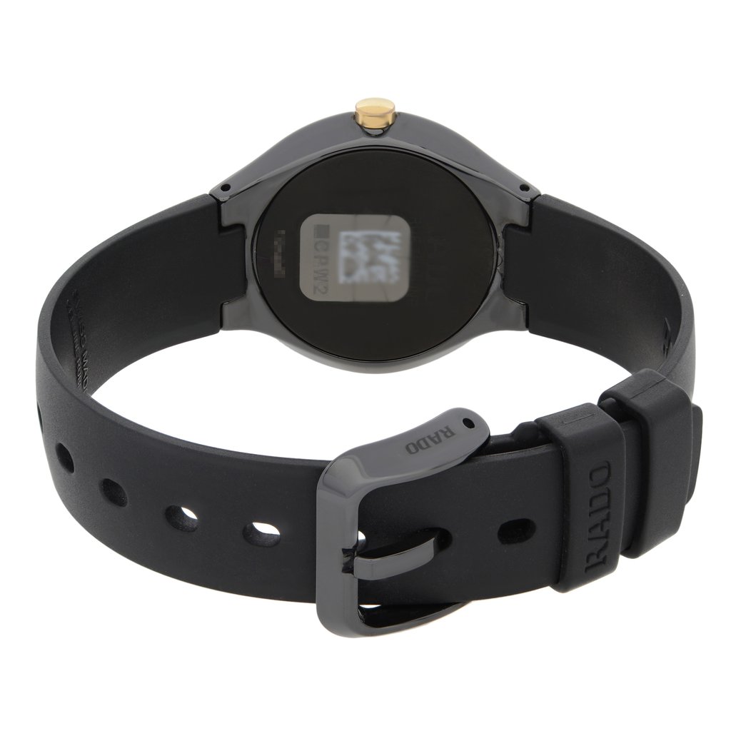 An image of a wristwatch displayed from a back view angle, focusing on the clasp. The watch is positioned slightly tilted, showing the smooth black band and a partially reflective back case with a small gold accent on top. The close-up perspective highlights the new condition of the watch, which has minor defects, and the brand name visible on the clasp.