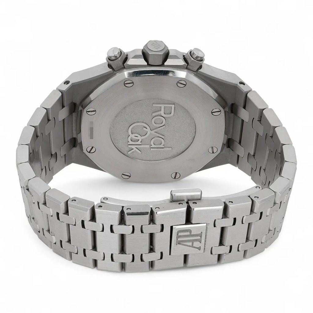 An image of a pre-owned Audemars Piguet men's wristwatch, viewed from the back at a slight angle. The watch features a stainless steel bracelet with a visible AP logo on the clasp. The case back is prominently engraved with "Royal Oak." The image is taken from a close distance, highlighting the watch's intricate design details and craftsmanship.