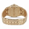 An image of a pre-owned Audemars Piguet women's wristwatch, prominently displaying the back view. The watch is positioned at a slight angle, facing upwards to reveal the "Royal Oak" engraving on the case back. The yellow gold bracelet, featuring a series of interlocking links, extends outward, filling the frame from a medium distance, showcasing its luxurious design and craftsmanship.