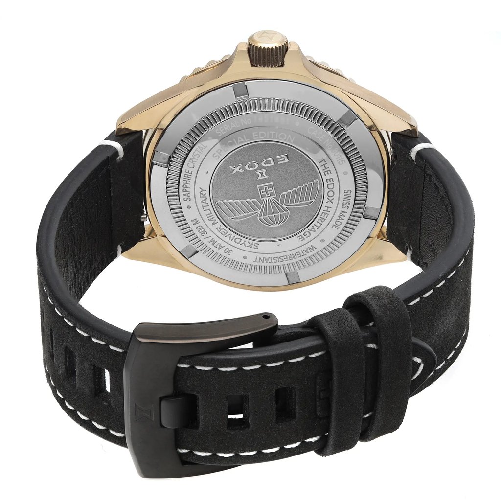 An image of a wristwatch seen from the back view, showcasing the close clasp. The watch is positioned upright, highlighting its round case and visible engravings on the backplate. The angle captures the gold-toned case and the textured black leather strap with white stitching. The image is taken from a close distance, emphasizing the details of the display model's design and craftsmanship.