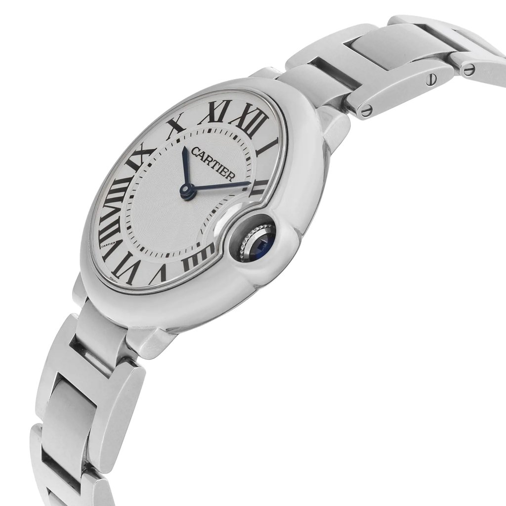 An image of a pre-owned Cartier unisex dress wristwatch, shown in a side profile view with the crown visible. The watch features a round shape with a silvered guilloché dial, black Roman numerals, and blue hands. A blue cabochon is set in the crown. The steel bezel encircles the dial, and the stainless steel band connects at a close angle to the case, emphasizing the watch's elegant design. The image is a close-up, focusing on the watch's details and craftsmanship.