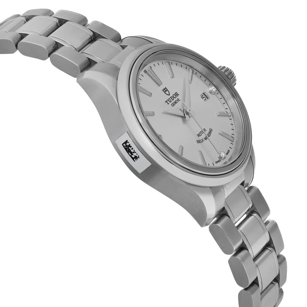 An image of an unworn wristwatch captured from a side profile view, opposite the crown. The angle highlights the sleek design and details of the watch's face and metallic bracelet. The perspective provides a clear view of the watch's side, showcasing its polished finish and craftsmanship from a close distance.