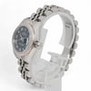 An image of a pre-owned women's Rolex wristwatch, viewed from a slightly angled side position. The watch is positioned close-up, highlighting its luminous hands and the detailed design of the Roman numeral dial. The stainless steel band is partially visible, emphasizing its polished finish.