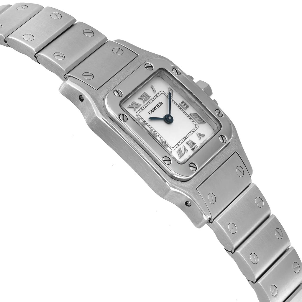 An image of a pre-owned Cartier luxury wristwatch for women, viewed from the side opposite the crown, showcasing its square shape. The watch features a white dial with Roman numerals, blue hands, and a gray bezel. It has a stainless steel band and case, presented in a close-up angle that emphasizes the watch's profile.