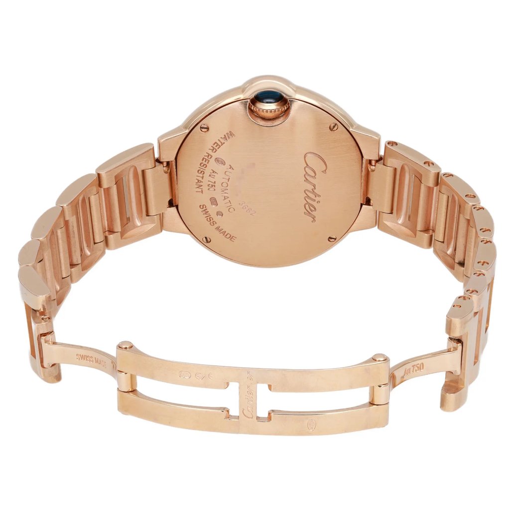 An image of a pre-owned wristwatch viewed from the back. The focus is on the closed clasp and the back case, showcasing the brand name and details. The watch is positioned at a slight angle to highlight the rose gold metal finish and the links of the bracelet. The photo is taken from a close distance, emphasizing the intricate design and craftsmanship.