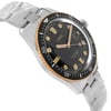 An image of a wristwatch displayed as a side profile view, opposite the crown. The watch features a black dial with gold-tone markers and hands, surrounded by a gold and black bezel. It is attached to a silver metal bracelet. The watch is a display model and is positioned at an angle that highlights its sleek design and craftsmanship.