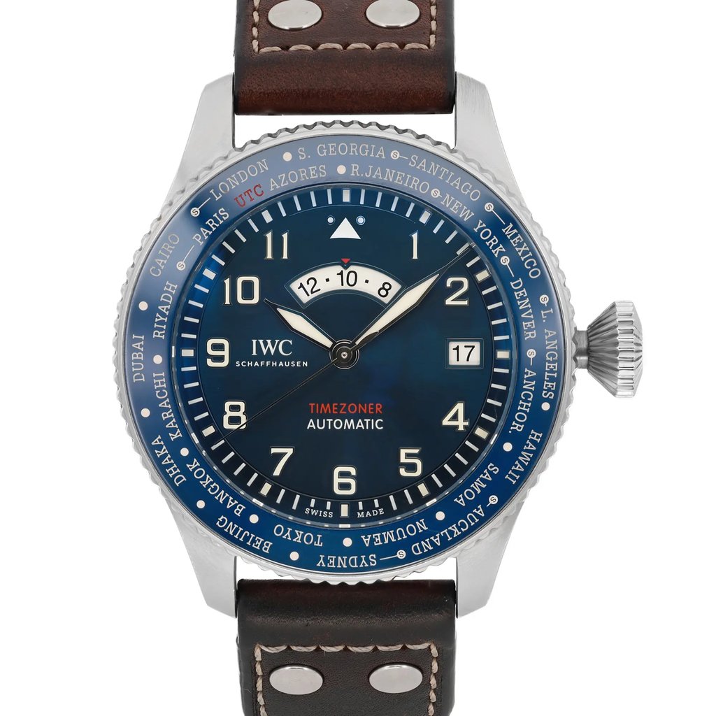 An image of a pre-owned IWC Timezoner Le Petit Prince Edition men's wristwatch taken from a front-facing angle at a close distance. The watch features a blue dial with luminous hands, a date display, and multiple city names on the bezel for time zone reference. The silver case is complemented by a brown leather strap with visible stitching and metal rivets. The crown is positioned on the right side of the watch.