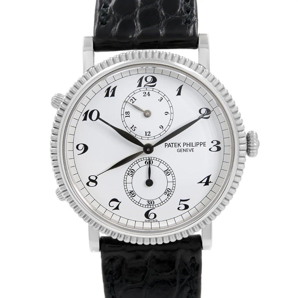 An image of a pre-owned wristwatch, captured in a front close-up shot. The watch face features a classic design with black numerals and a sub-dial for additional functionality. The case has a detailed, textured edge, and the strap is made of black leather with a textured pattern. The brand name is visible on the watch face.