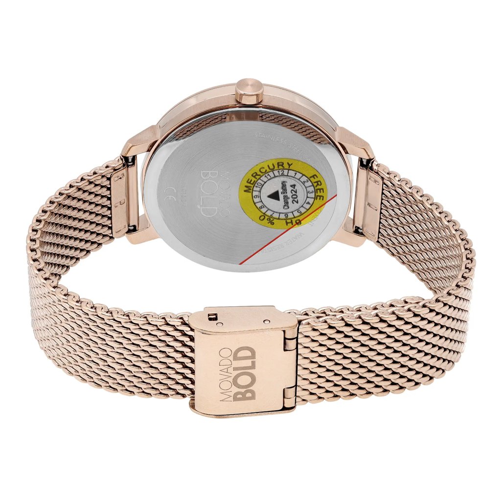 An image of a wristwatch showing the back view with a close clasp. The watch features a metallic mesh band and the back casing displays a "Mercury Free" sticker. The watch is positioned upright, highlighting its new condition despite noted defects. The image is taken from a close angle, emphasizing the details of the clasp and the back of the watch.