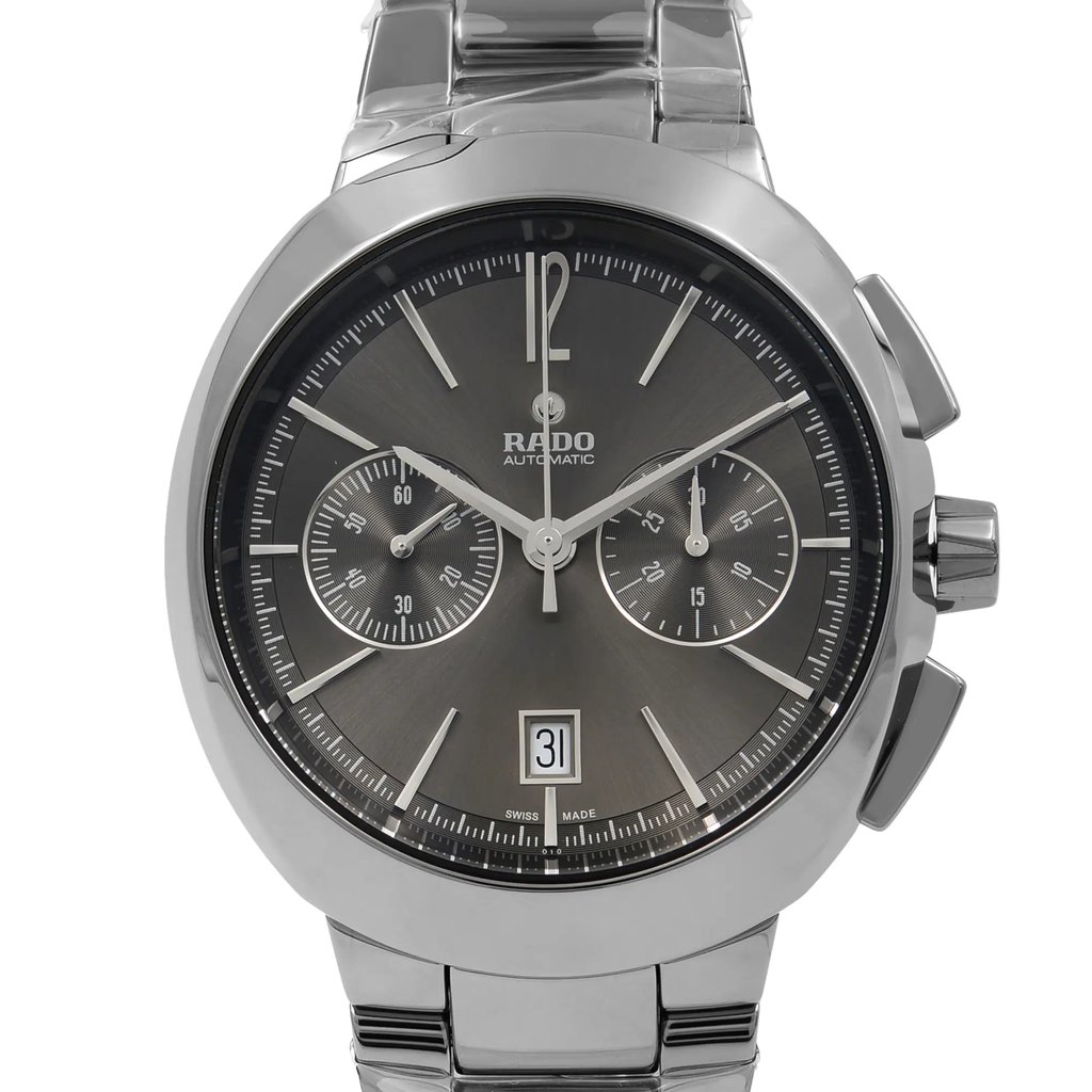 An image of a new wristwatch captured from a front close-up angle, highlighting the watch face. The watch features a metallic band and a sleek, dark dial with silver-tone hands and markers. The brand name is visible on the upper center of the dial, with sub-dials for additional functionality and a date window at the bottom. The overall design is modern and elegant.