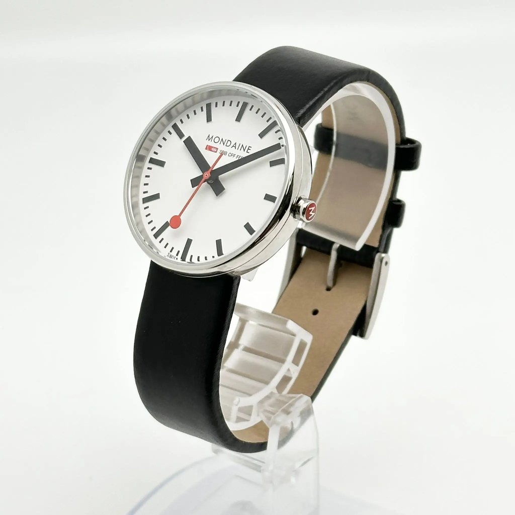 An image of a Wristwatch by Mondaine. This Display Model item is designed for Unisex Adult, featuring a Casual,Classic,Dress/Formal style. It has a Quartz movement and an Analog display with a White dial color. The indices include 12-Hour Dial,Non-Numeric Hour Marks,Stick Indexes. The band is made of Leather and the case is made of Stainless Steel. The watch has a Round shape with a case size of 35 mm and a case thickness of 10 mm.