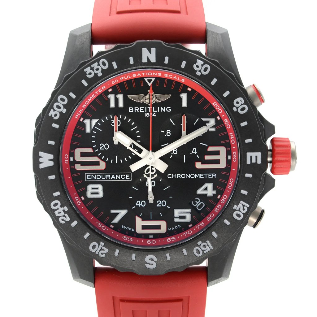 An image of a Breitling men's sport wristwatch, displayed in excellent condition from a front close-up perspective. The watch face is in focus, featuring a round black dial with Arabic numerals and a 12-hour index. The bezel is also black with a pulsometer scale. The Breitling logo is visible just below the 12 o'clock position. The watch has a Breitlight case and a red rubber band, with the word "ENDURANCE" and "CHRONOMETER" inscribed on the dial. Positioned against a white background, the watch is shot at a close distance, providing a clear view of the details and angles of the watch face. Can have minor blemishes on the watch during handling and shipping. 
