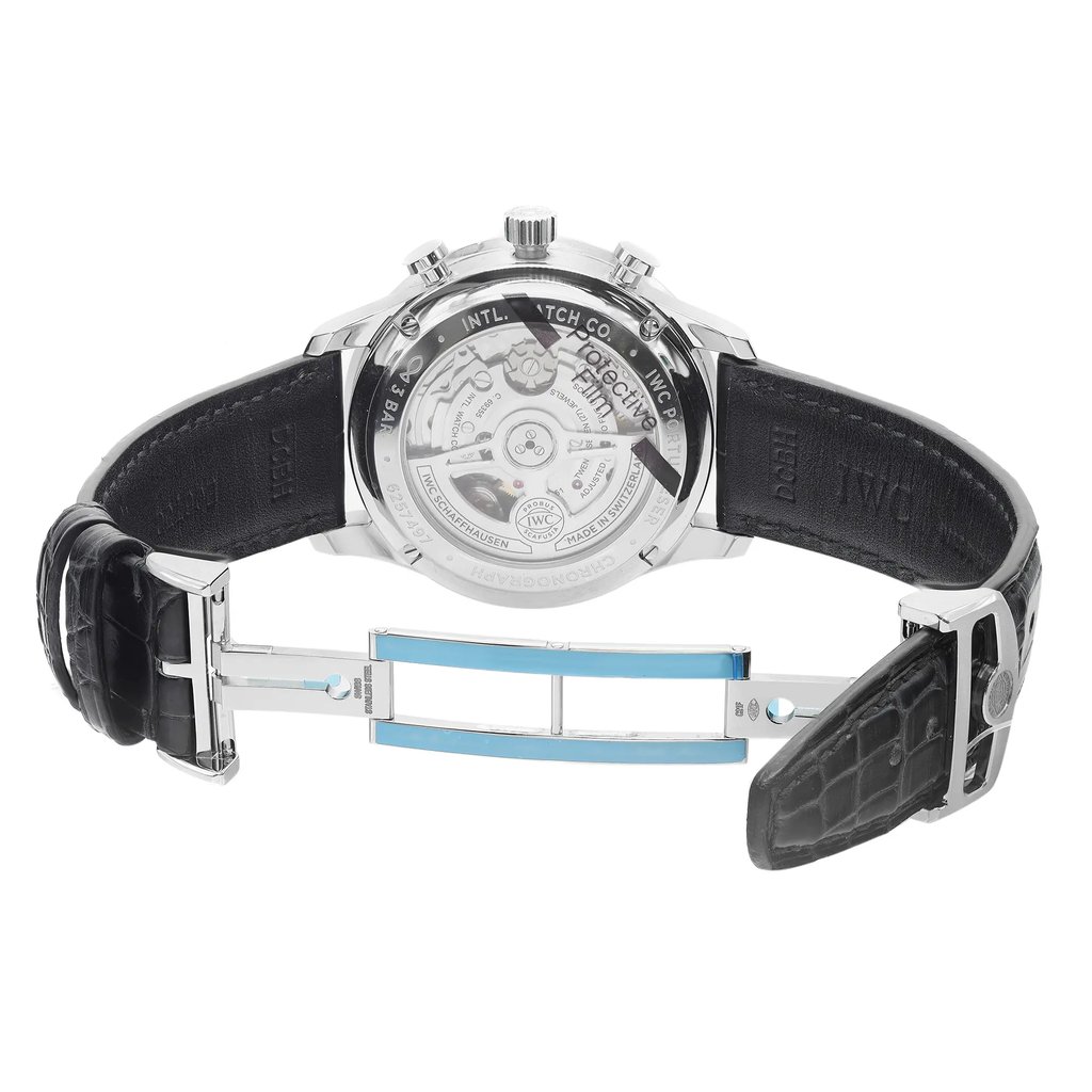 An image of an unworn IWC men's wristwatch with a stainless steel case and exhibition caseback. The watch is shown from the back view with an open deployant clasp and a round watch shape. The leather band is black, and the watch is positioned at a slight angle to clearly display the intricate details of the caseback and the structure of the clasp. The image is taken from a medium distance, allowing the entire watch to be visible.