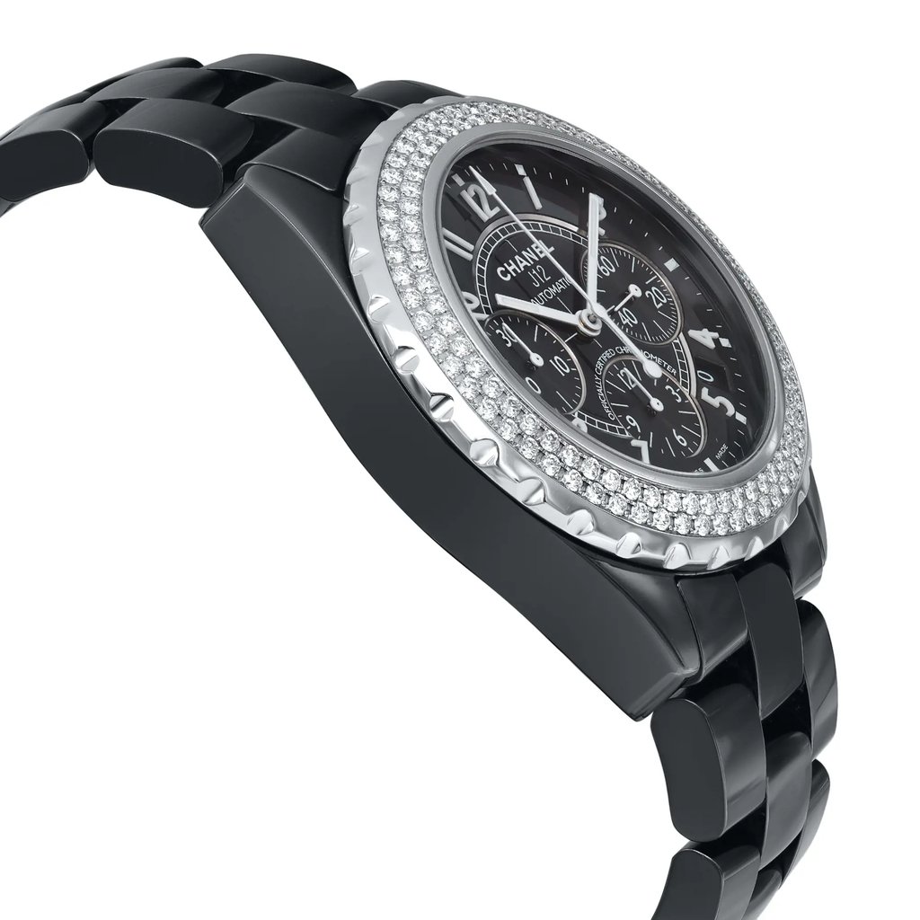 An image of a pre-owned wristwatch captured from a side profile view, opposite the crown. The watch features a black band with a polished finish, and a round face with a diamond-accented bezel. The angle highlights the watch's thickness and the intricate detailing on the face, displaying multiple sub-dials. The photo is taken at a close distance, emphasizing the luxurious design and craftsmanship.