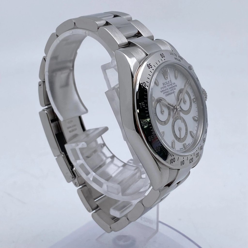 An image of a pre-owned men's Rolex wristwatch positioned at a three-quarter angle from the left side. The watch is elevated on a display stand, showcasing its stainless steel bracelet and detailed face. The chronograph features, luminous hands, and small seconds subdial are clearly visible. The watch is photographed from a close distance, highlighting its polished finish and intricate design elements.