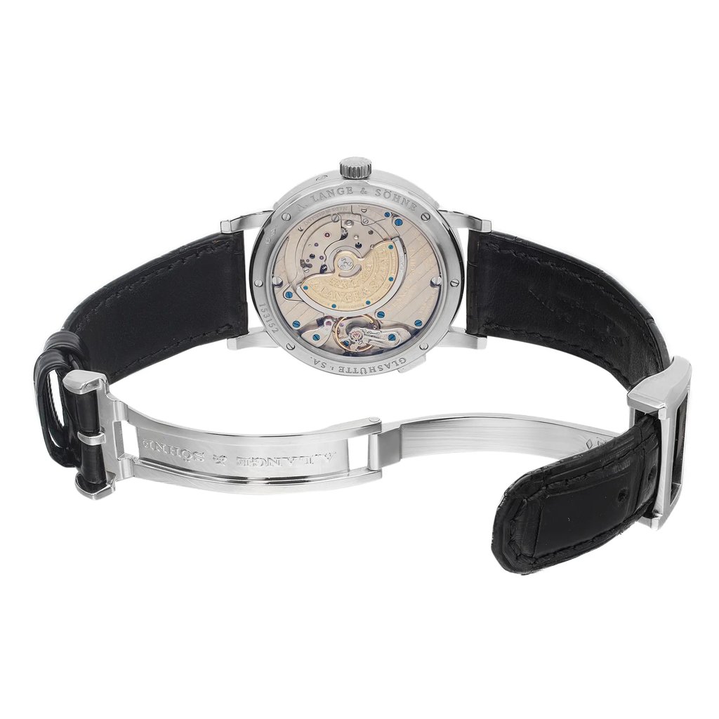 An image of a pre-owned wristwatch viewed from the back, showcasing the open clasp. The watch is positioned at a slight angle, allowing a clear view of the intricate mechanical movement through the transparent case back. The black leather strap is partially visible, with the metal clasp open and engraved. The photo is taken at a close distance, emphasizing the craftsmanship and details of the watch.