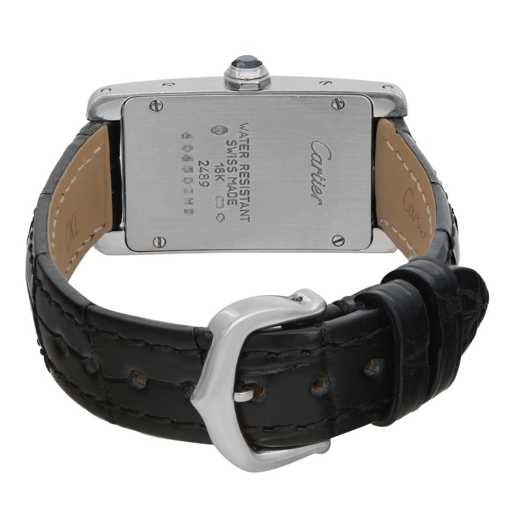 An image of a pre-owned wristwatch showing the back view with a close-up of the clasp. The watch has a rectangular metal case with visible screws at the corners and engraved details on the back. The leather strap is black and features a silver buckle. The angle captures the watch from a slightly elevated position, focusing on the clasp.